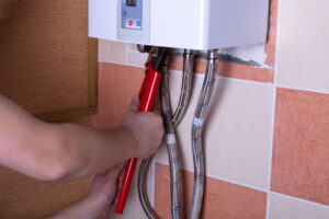 technician-hand-working-on-pipes-of-tankless-water-heater