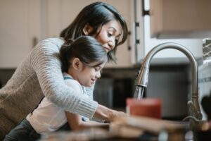 asian-mother-and-daughter-using-kitchen-sink
