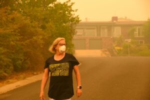 woman-wearing-n95-mask-outside-her-home-wildfire-smoke